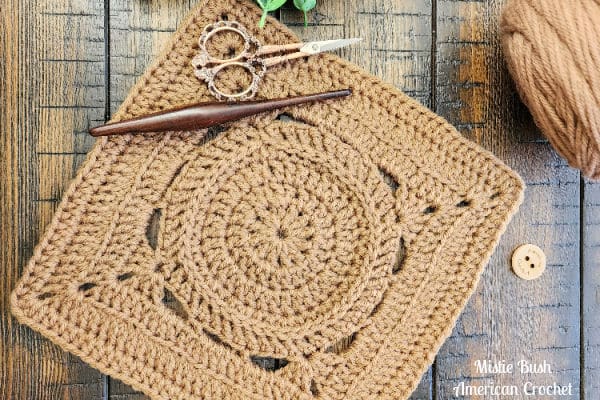 Pedigo Square crochet pattern – a textured 9-inch crochet afghan block in tan brown, featuring herringbone double crochet and back loop stitches. Part of the Riverwood Square CAL 2025
