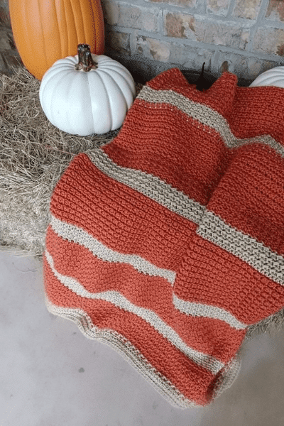 Buttercup Spice Crochet Blanket in cozy orange and cream fall colors, featuring a textured crochet pattern | American Crochet