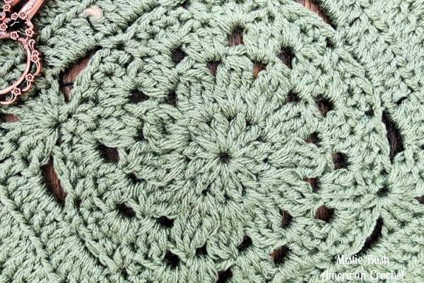 Close-up of the Enclave Square's texture, featuring raised cluster stitches and clean back loop detail in a 9-inch modern crochet block.