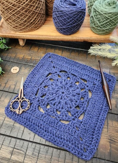 Blessed Square crochet pattern – 9-inch square using treble crochet and back loop only stitches. Styled flat with scissors and wooden crochet hook.